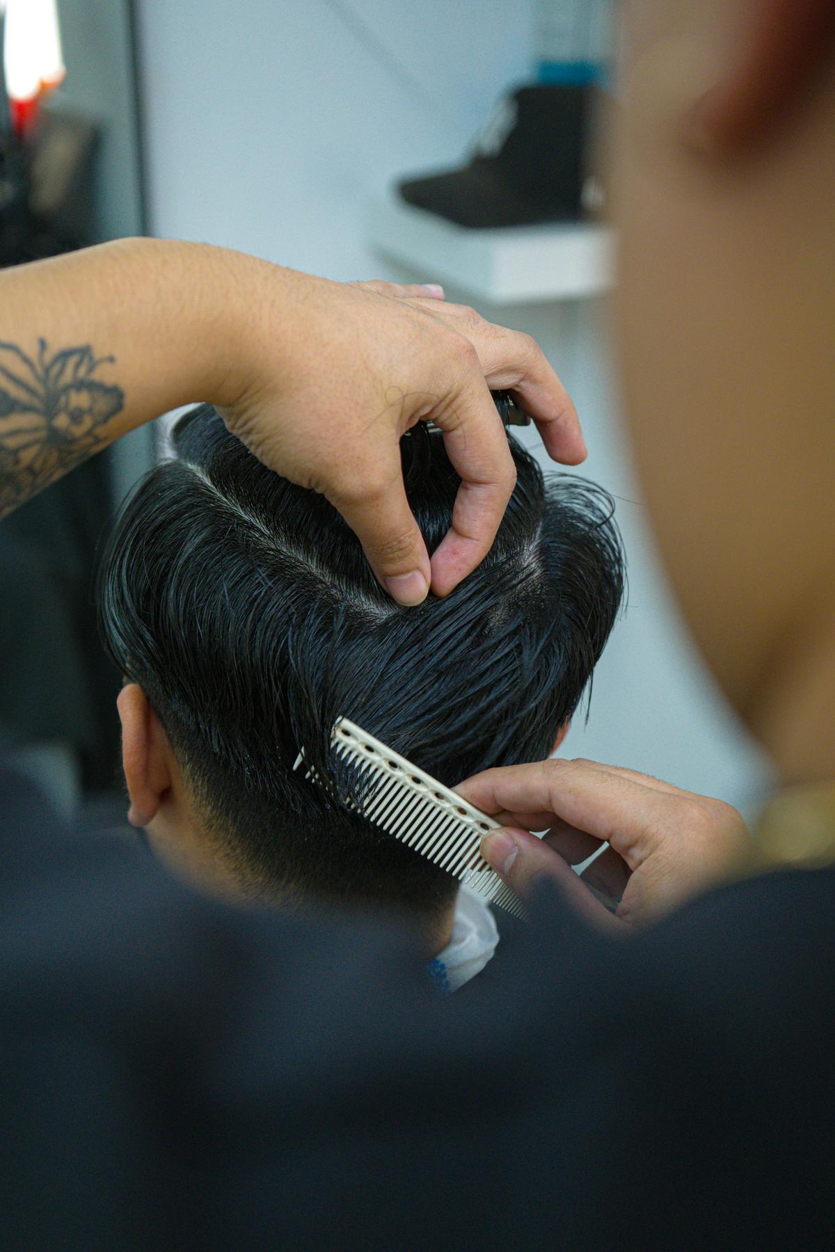 Barbier kamt het haar in model