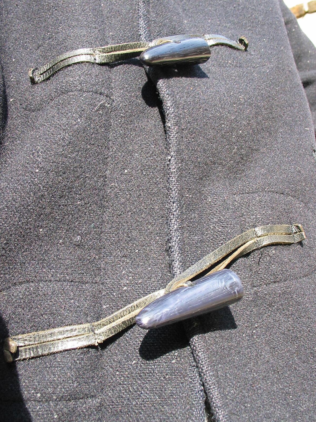 Houten knevels en lussen op een grijze duffelcoat